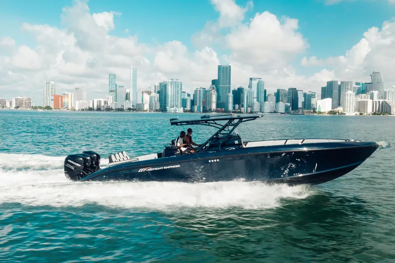 Slide: The Image of 2014 Midnight Express 37’ Open boat cruising near city skyline on a sunny day. - 11