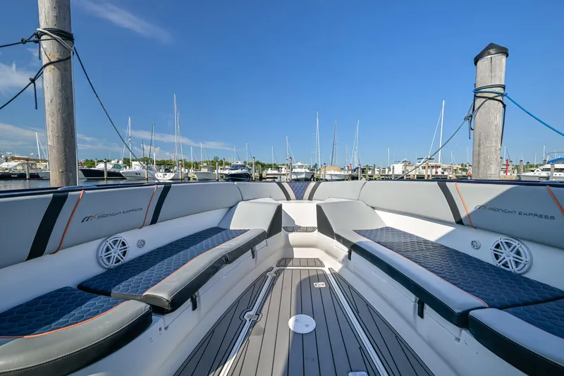 Slide: The Image of 2014 Midnight Express 37’ Open boat interior with seating, docked at marina under clear blue sky. - 15