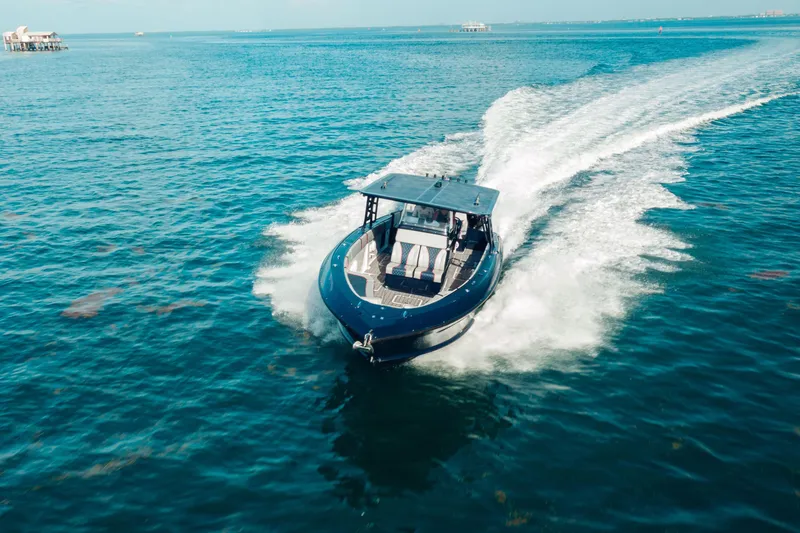 Slide: The Image of 2014 Midnight Express 37’ Open boat cruising on clear blue water. - 2