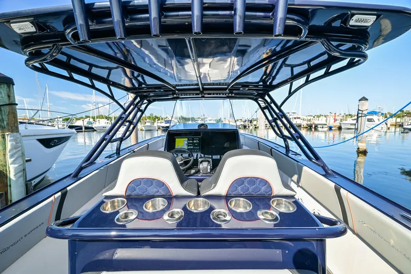 Slide: The Image of 2014 Midnight Express 37’ Open boat interior with helm, cup holders, and marina view. - 29