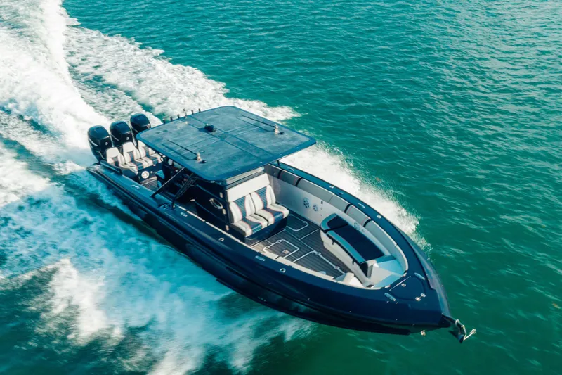 Slide: The Image of 2014 Midnight Express 37’ Open boat cruising on clear blue water. - 4