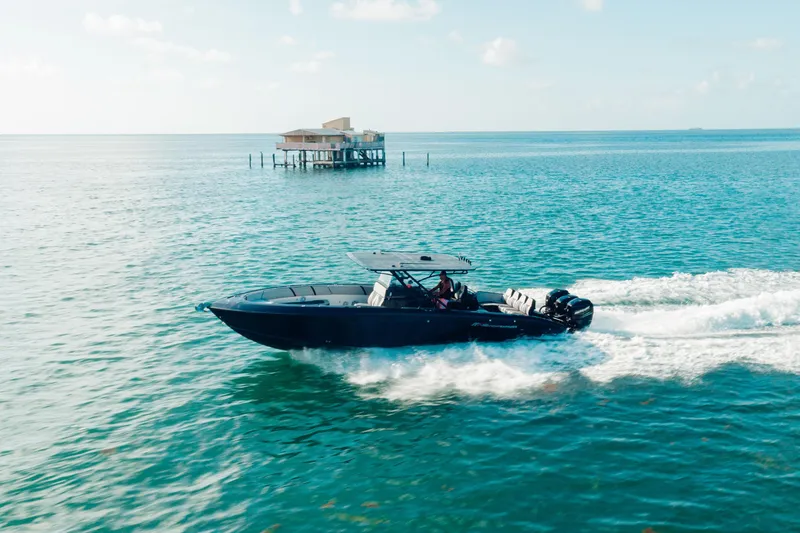 Slide: The Image of 2014 Midnight Express 37’ Open boat cruising on clear blue ocean waters. - 6