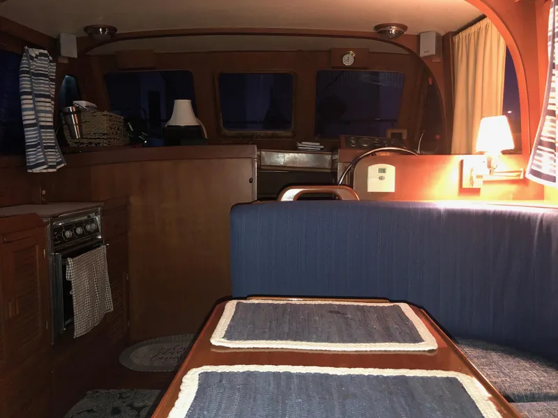Slide: The Image of Interior of 1986 Albin 36 Trawler with cozy dining area and ambient lighting. - 10