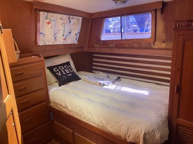 Slide: The Image of Cozy cabin interior of 1986 Albin 36 Trawler with bed, wooden drawers, and window. - 11