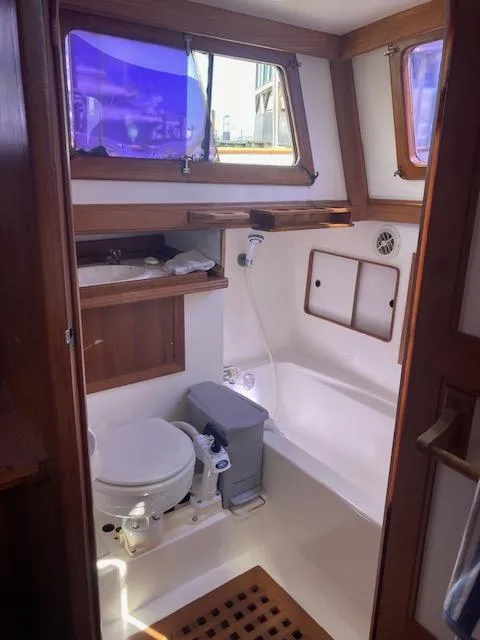 Slide: The Image of 1986 Albin 36 Trawler bathroom with wooden accents and nautical fixtures. - 14