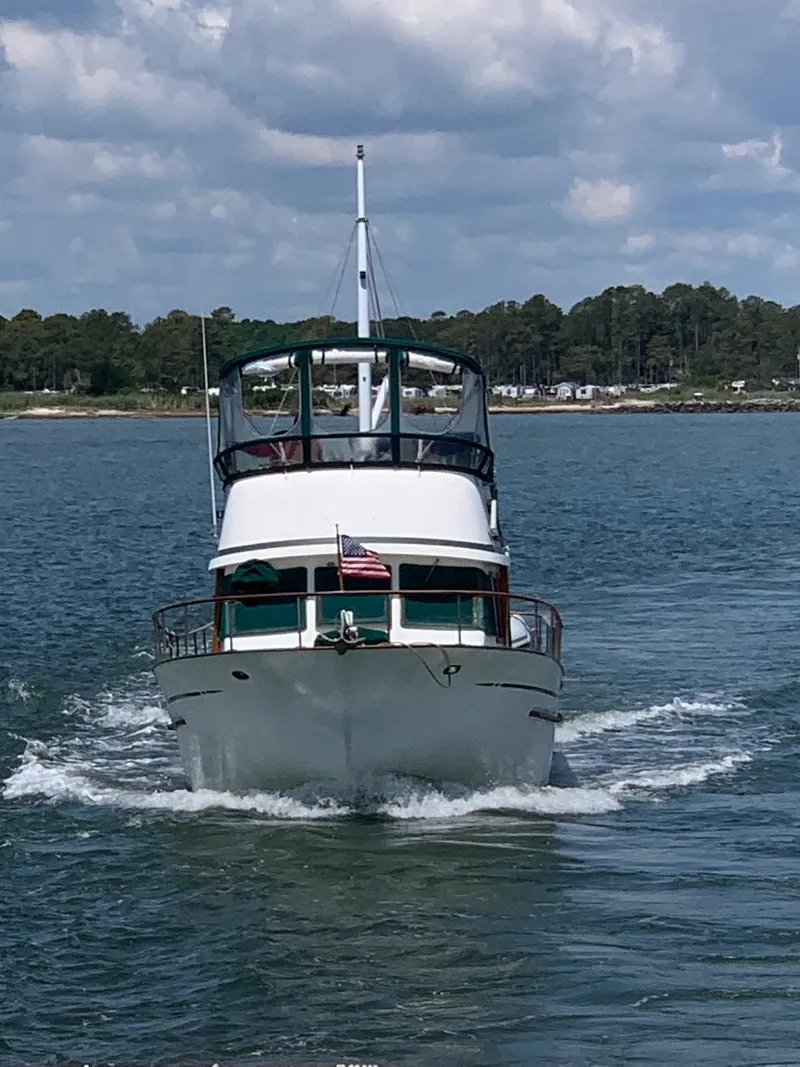 Slide: The Image of 1986 Albin 36 Trawler cruising on a calm lake under a partly cloudy sky. - 2