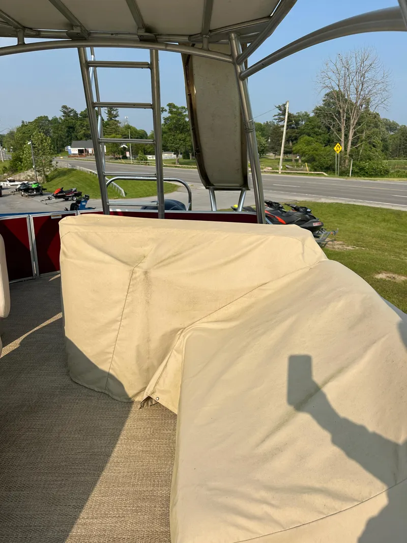 Slide: The Image of 2017 Godfrey Sweetwater 2386 CC boat interior with covered seating and outdoor view. - 17