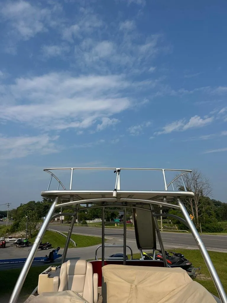 Slide: The Image of 2017 Godfrey Sweetwater 2386 CC boat with canopy under a clear blue sky. - 21