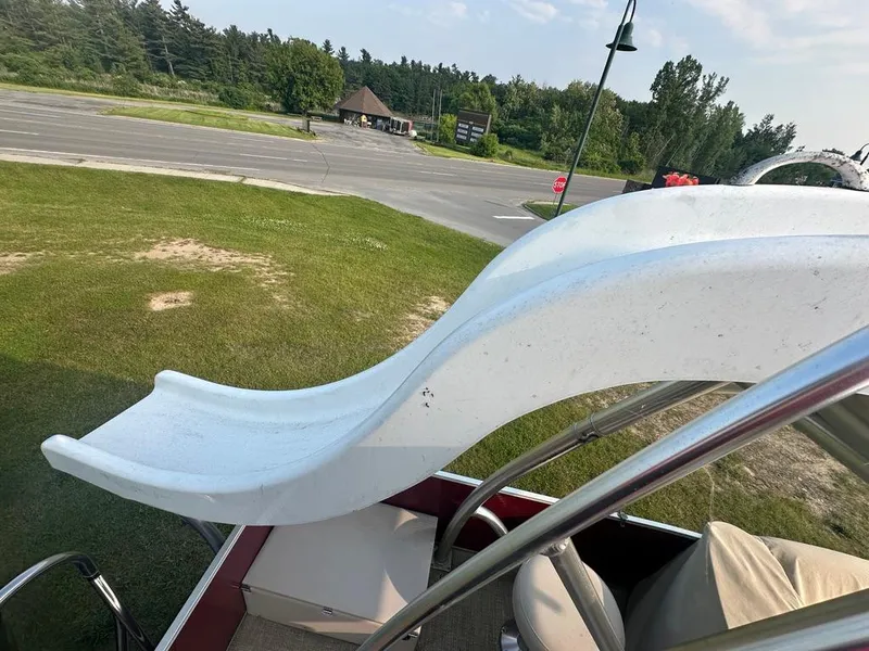 Slide: The Image of 2017 Godfrey Sweetwater 2386 CC boat with slide, parked on grass near road. - 22