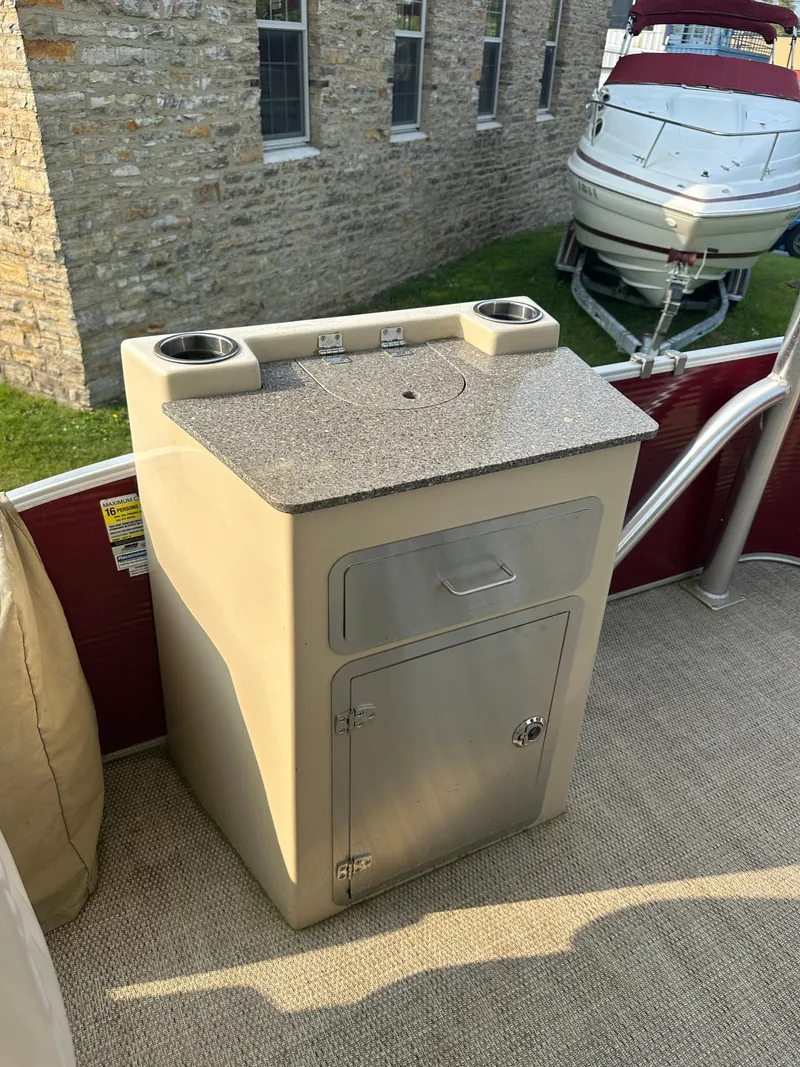 Slide: The Image of 2017 Godfrey Sweetwater 2386 CC boat interior with storage cabinet and cup holders. - 28