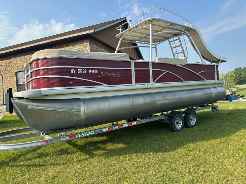 Slide: The Image of 2017 Godfrey Sweetwater 2386 CC pontoon boat on trailer, parked on grass. - 3
