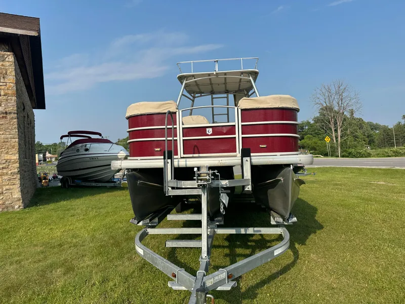 Slide: The Image of 2017 Godfrey Sweetwater 2386 CC pontoon boat on trailer, parked on grass. - 4