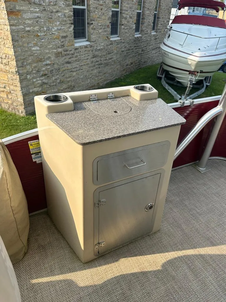 Slide: The Image of 2017 Godfrey Sweetwater 2386 CC boat console with storage and cup holders. - 7