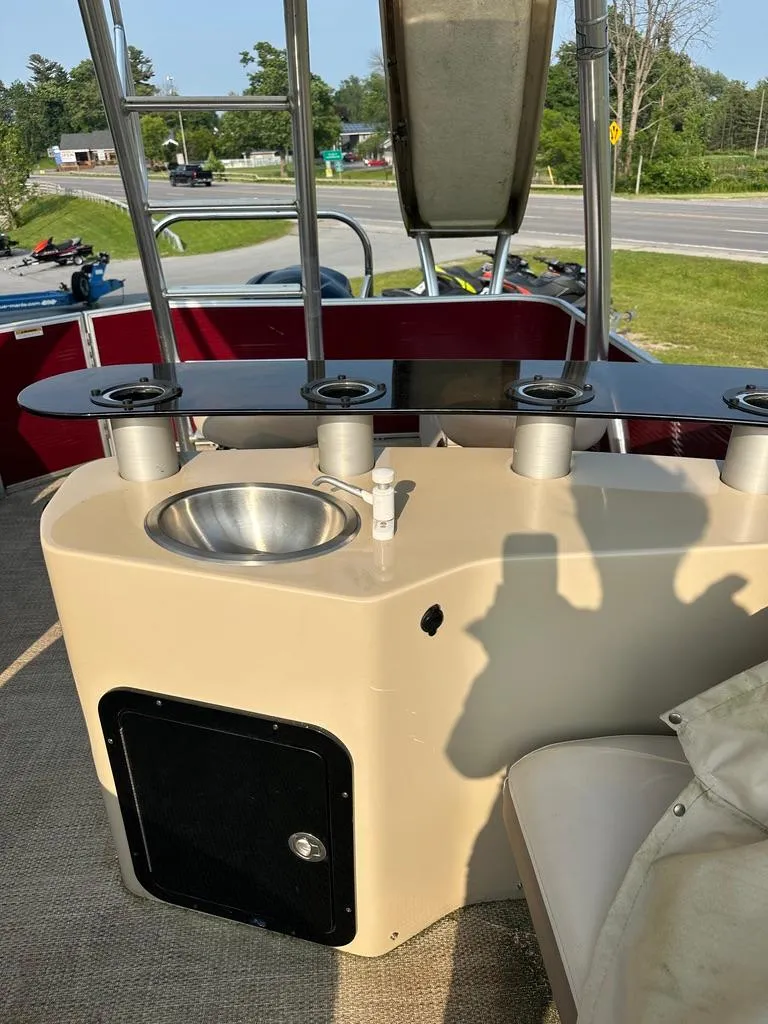 Slide: The Image of 2017 Godfrey Sweetwater 2386 CC boat interior with sink and rod holders. - 8