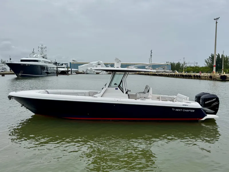Slide: The Image of 2018 Intrepid 327 Center Console boat docked in a marina, side view. - 1