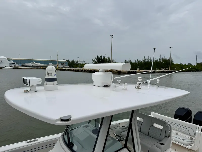 Slide: The Image of 2018 Intrepid 327 Center Console boat with advanced navigation equipment on a cloudy day. - 11
