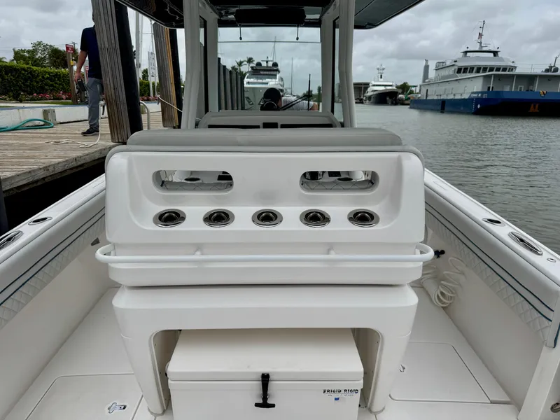 Slide: The Image of 2018 Intrepid 327 Center Console boat with seating and rod holders, docked by the water. - 15