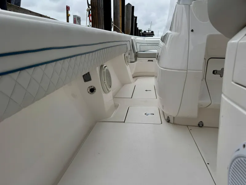 Slide: The Image of 2018 Intrepid 327 Center Console boat interior with white seating and storage compartments. - 17