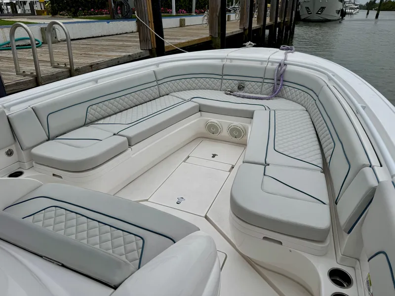 Slide: The Image of 2018 Intrepid 327 Center Console boat with spacious seating and elegant design at a dock. - 19