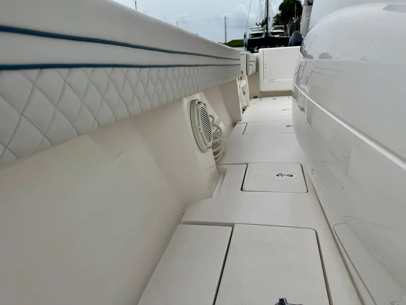Slide: The Image of 2018 Intrepid 327 Center Console boat interior with quilted upholstery and storage compartments. - 23