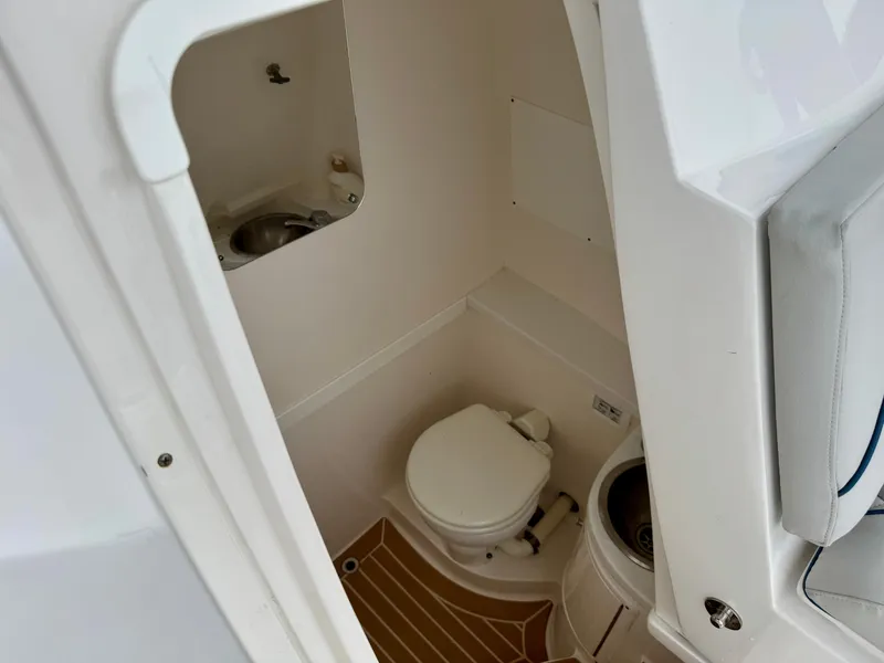 Slide: The Image of 2018 Intrepid 327 Center Console boat interior with compact bathroom and sink. - 27