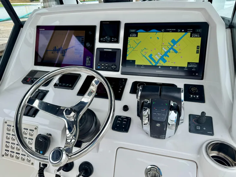 Slide: The Image of Control panel of a 2018 Intrepid 327 Center Console boat with navigation screens and steering wheel. - 5