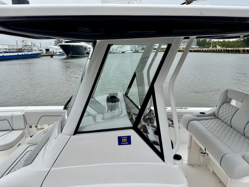 Slide: The Image of 2018 Intrepid 327 Center Console boat with sleek design, docked by the waterfront. - 7