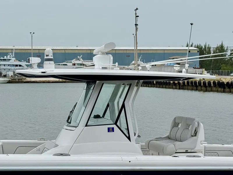 Slide: The Image of 2018 Intrepid 327 Center Console boat docked at marina, featuring sleek design and modern equipment. - 8