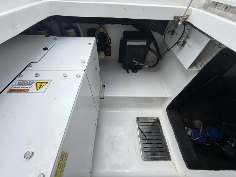 Slide: The Image of 2024 Front Runner 39 CC boat engine compartment with electrical components and warning labels. - 18