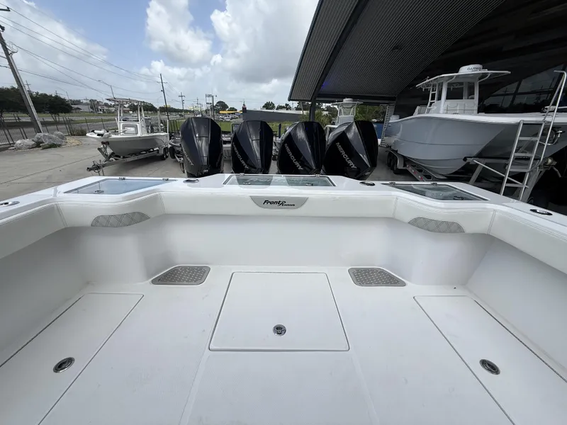 Slide: The Image of 2024 Front Runner 39 CC boat with multiple outboard engines, docked under a cloudy sky. - 24