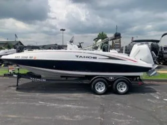 The Image of 2023 Tahoe 2150 Deck Boat CC on trailer, parked outdoors under cloudy sky. - 0