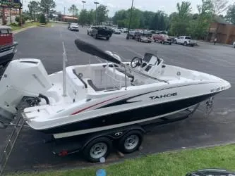 Slide: The Image of 2023 Tahoe 2150 Deck Boat CC on trailer in parking lot. - 1