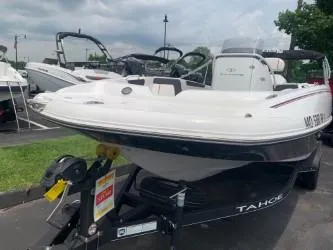 Slide: The Image of 2023 Tahoe 2150 Deck Boat CC on trailer, displayed outdoors. - 2