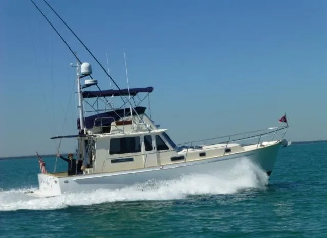Slide: The Image of 2004 Legacy Sedan Flybridge cruising on open water under clear blue sky. - 0