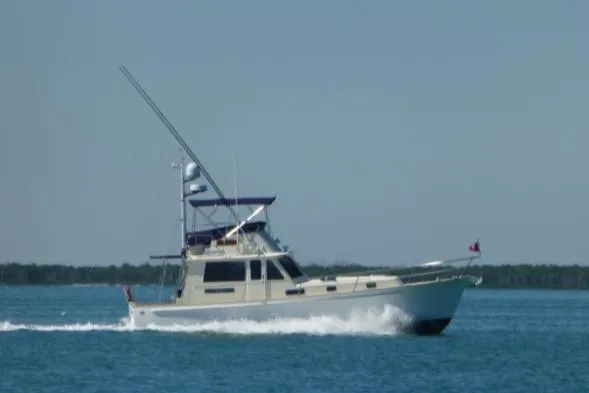 Slide: The Image of 2004 Legacy Sedan Flybridge cruising on calm blue waters. - 1