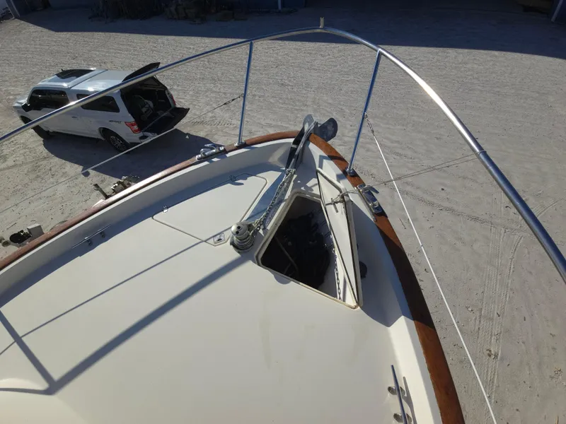 Slide: The Image of 2004 Legacy Sedan Flybridge boat with open hatch, parked car nearby on sandy ground. - 14