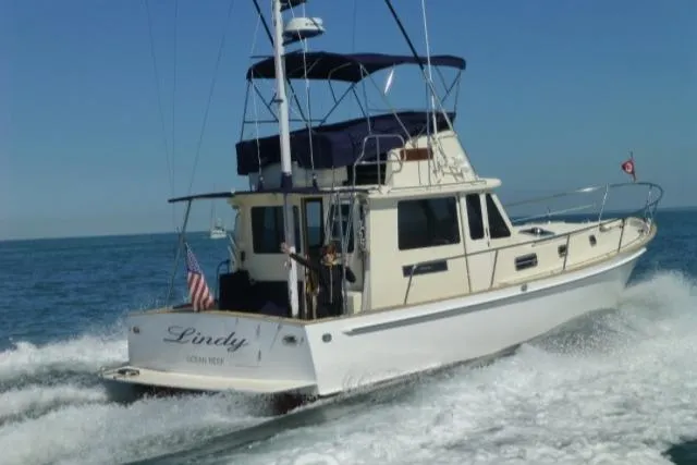 Slide: The Image of 2004 Legacy Sedan Flybridge boat cruising on open water, rear view. - 2