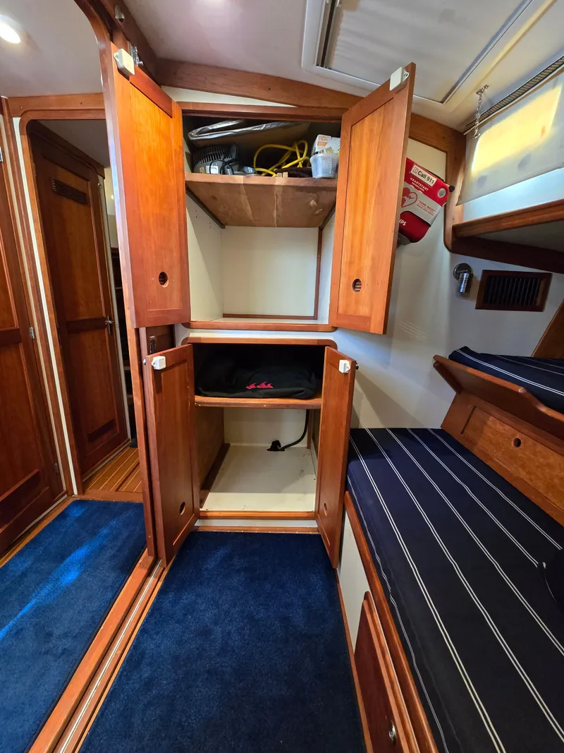 Slide: The Image of 2004 Legacy Sedan Flybridge interior with wooden cabinets and blue carpet. - 38