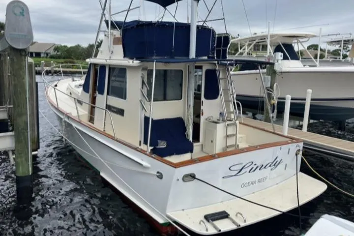 Slide: The Image of 2004 Legacy Sedan Flybridge boat docked at marina, named "Lindy" from Ocean Reef. - 4