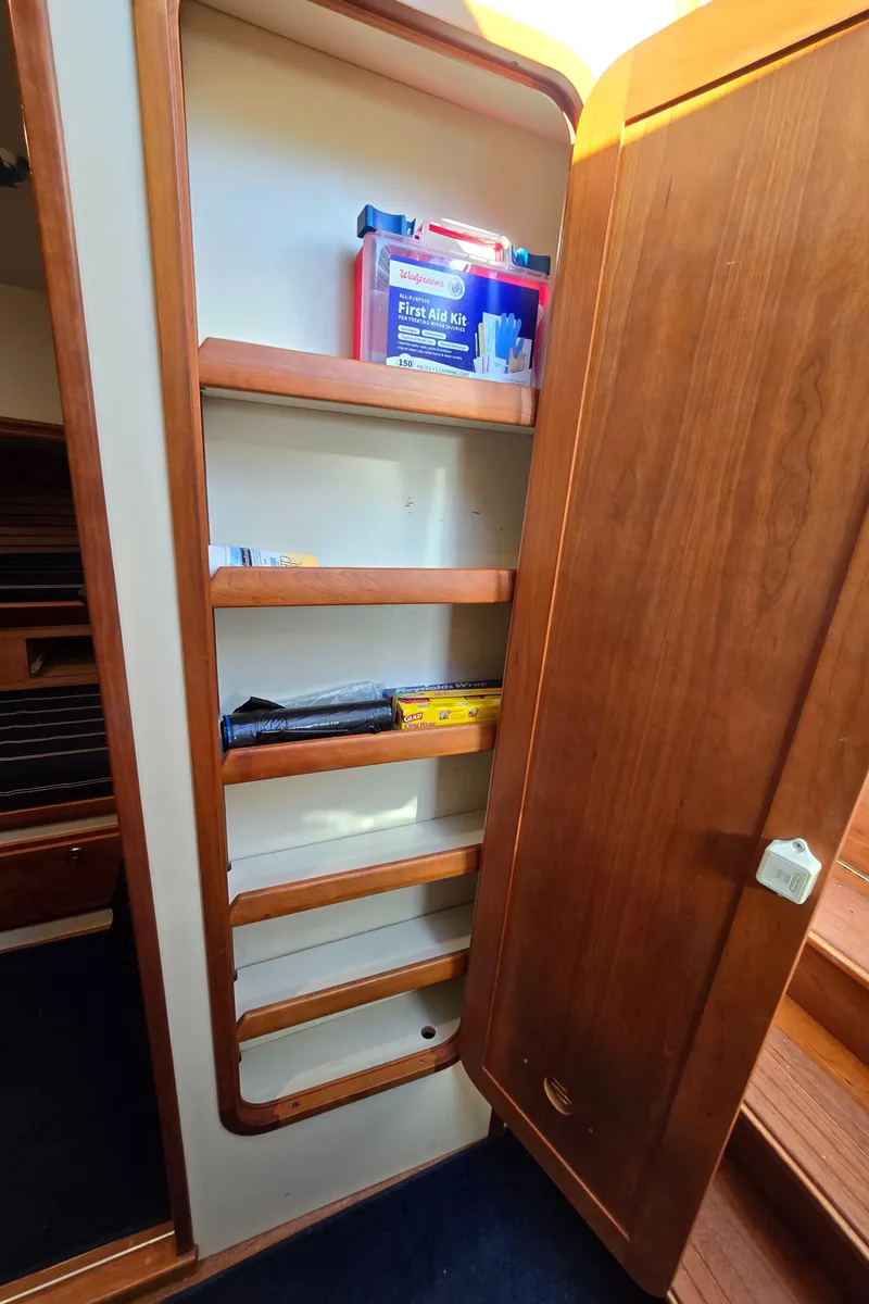 Slide: The Image of Wooden storage shelves inside a 2004 Legacy Sedan Flybridge boat. - 40