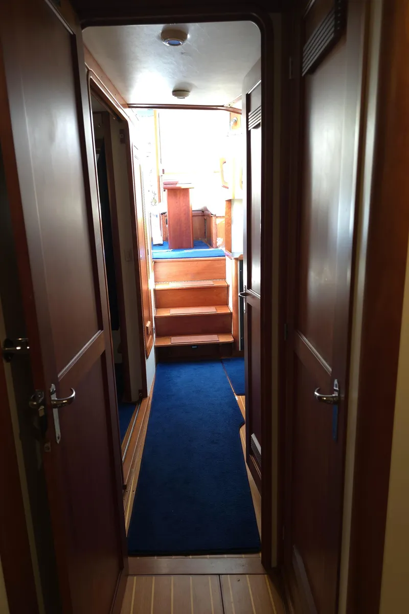 Slide: The Image of Interior hallway of 2004 Legacy Sedan Flybridge with wooden doors and blue carpet. - 41