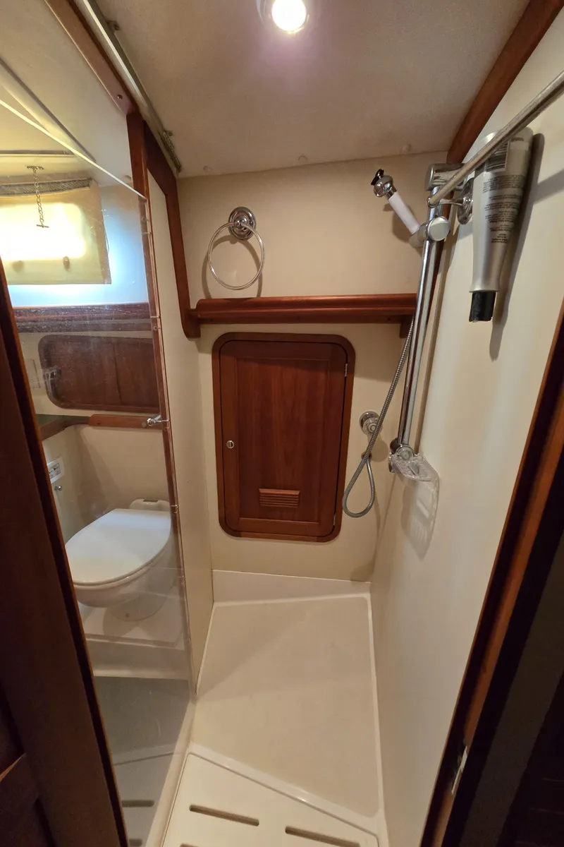 Slide: The Image of Compact bathroom in 2004 Legacy Sedan Flybridge with shower and wooden accents. - 49