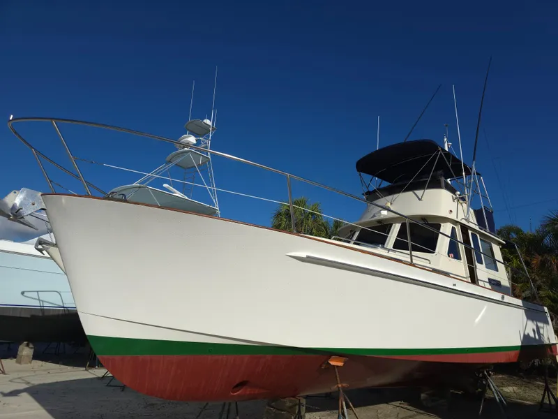 Slide: The Image of 2004 Legacy Sedan Flybridge boat on land under clear blue sky. - 6