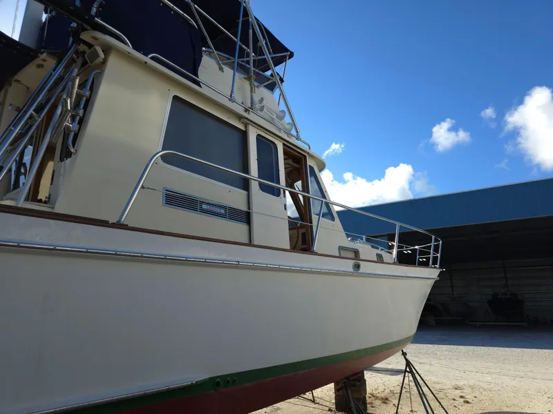 Slide: The Image of 2004 Legacy Sedan Flybridge boat on land, clear sky background. - 8