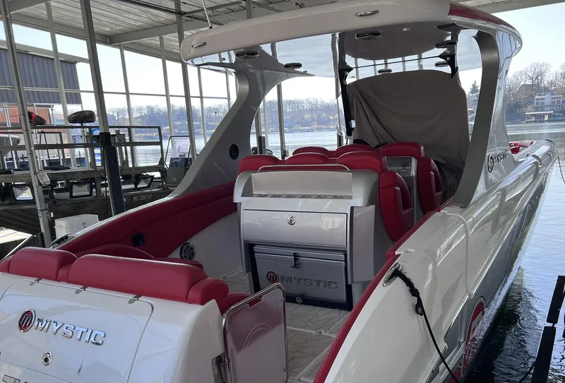Slide: The Image of 2019 Mystic Powerboats M4200 with red seating, docked in a covered marina. - 11