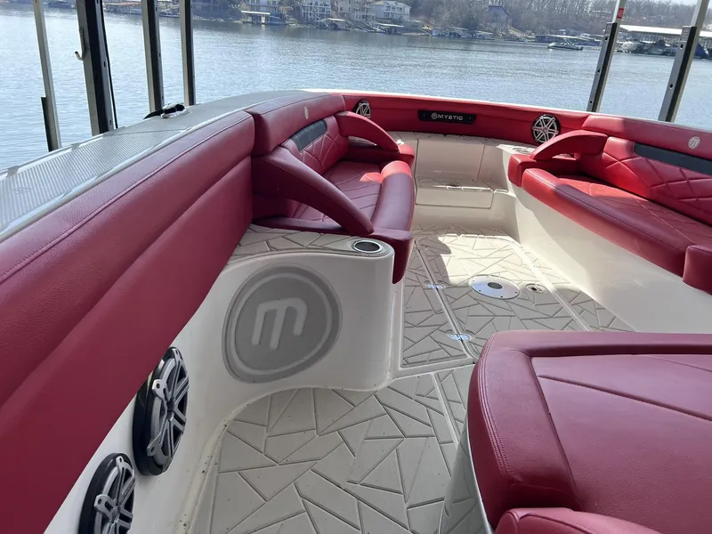 Slide: The Image of 2019 Mystic Powerboats M4200 with red seating, spacious deck, and lake view. - 19