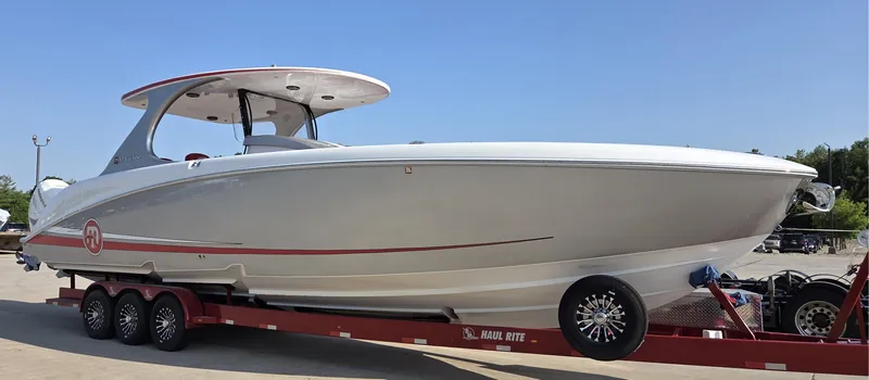 Slide: The Image of 2019 Mystic Powerboats M4200 on trailer, sleek design, white with red accents, clear sky background. - 2