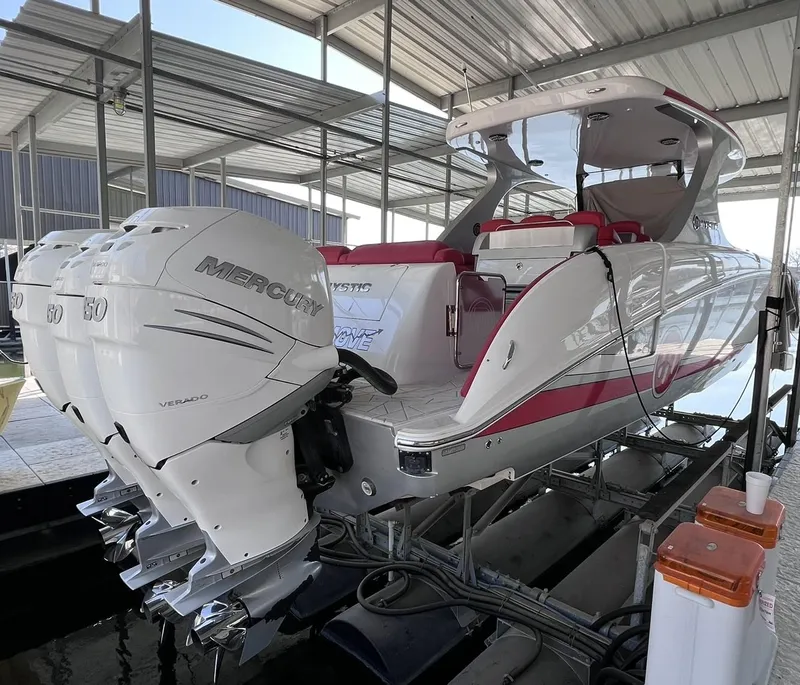 Slide: The Image of 2019 Mystic Powerboats M4200 with triple Mercury engines in a covered dock. - 3