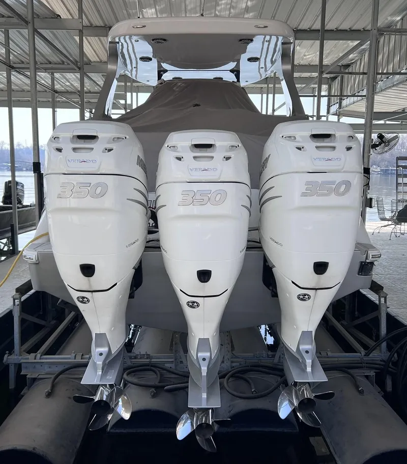 Slide: The Image of 2019 Mystic Powerboats M4200 with triple 350 horsepower engines in a covered dock. - 4
