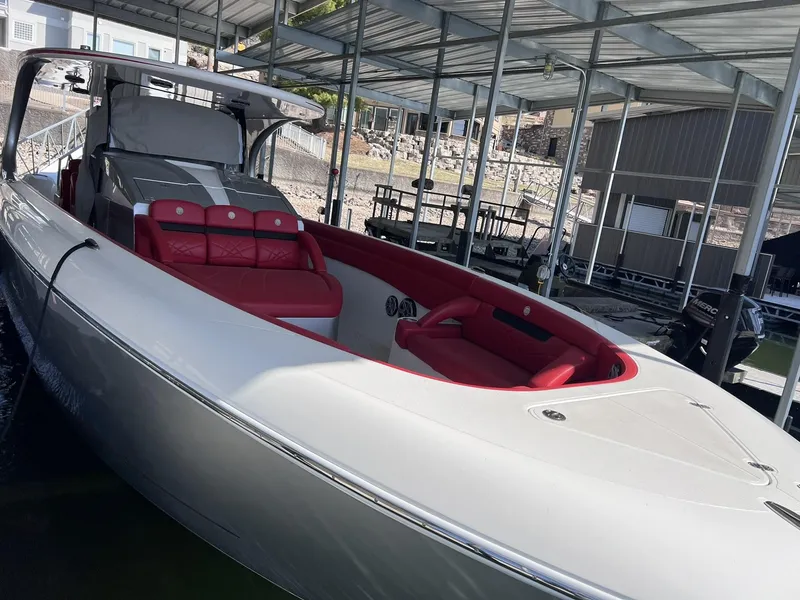 Slide: The Image of 2019 Mystic Powerboats M4200 with red seating, docked under a covered marina. - 8